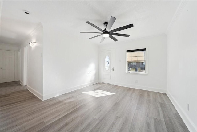 empty room with ceiling fan, crown molding, and light hardwood / wood-style flooring