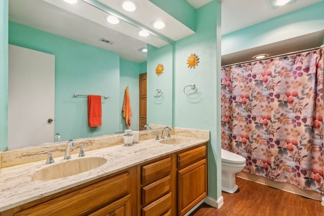 bathroom featuring vanity, hardwood / wood-style flooring, toilet, and curtained shower