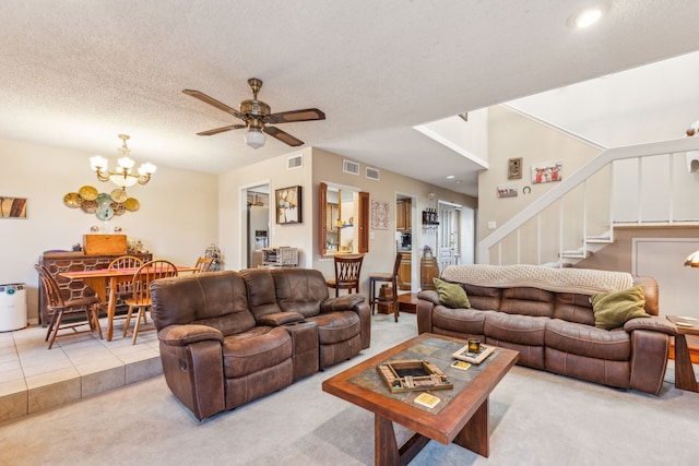 living room featuring a textured ceiling, light carpet, and ceiling fan with notable chandelier