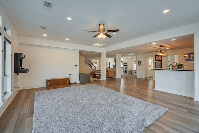 unfurnished living room with light hardwood / wood-style flooring and ceiling fan