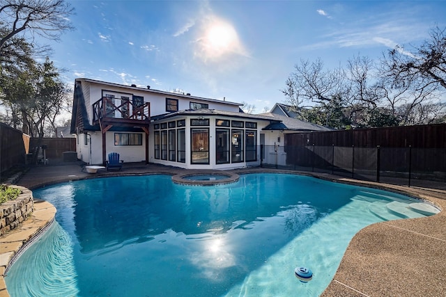 view of pool featuring a sunroom and an in ground hot tub