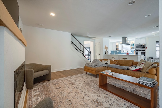 living room with sink and light hardwood / wood-style flooring