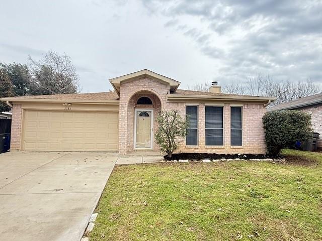 view of front of home with a garage and a front lawn