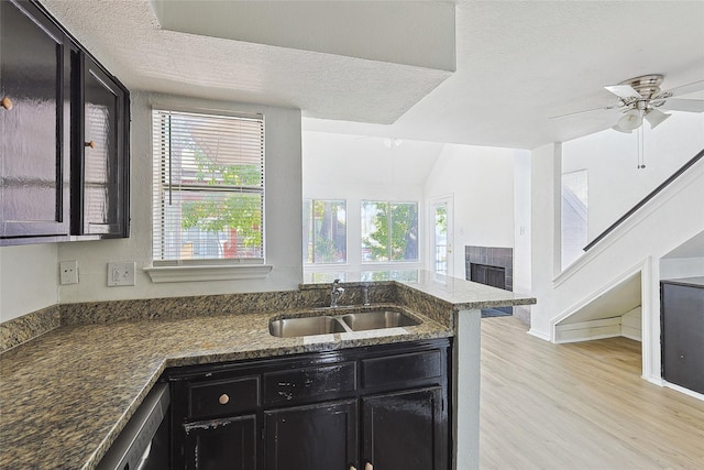 kitchen featuring ceiling fan, plenty of natural light, dark stone countertops, and sink