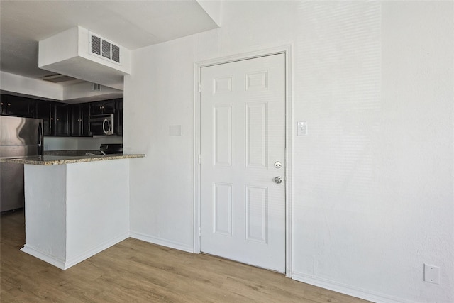 kitchen featuring kitchen peninsula, light hardwood / wood-style floors, and appliances with stainless steel finishes