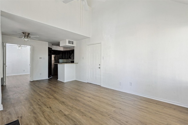 unfurnished living room featuring hardwood / wood-style floors and ceiling fan