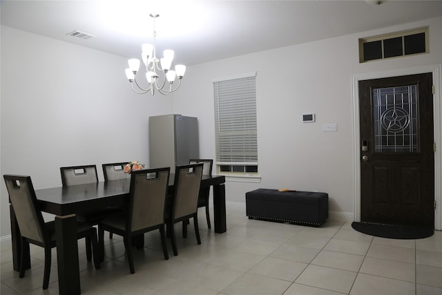 tiled dining space with a chandelier