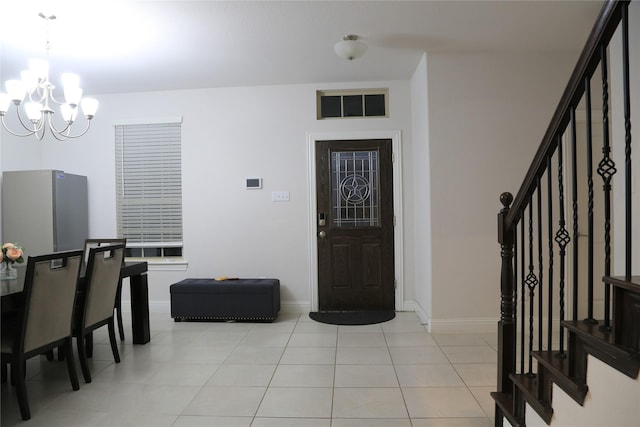 tiled entryway with an inviting chandelier