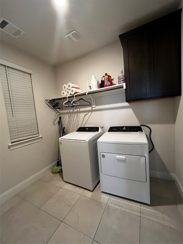 washroom with cabinets, independent washer and dryer, and light tile patterned floors