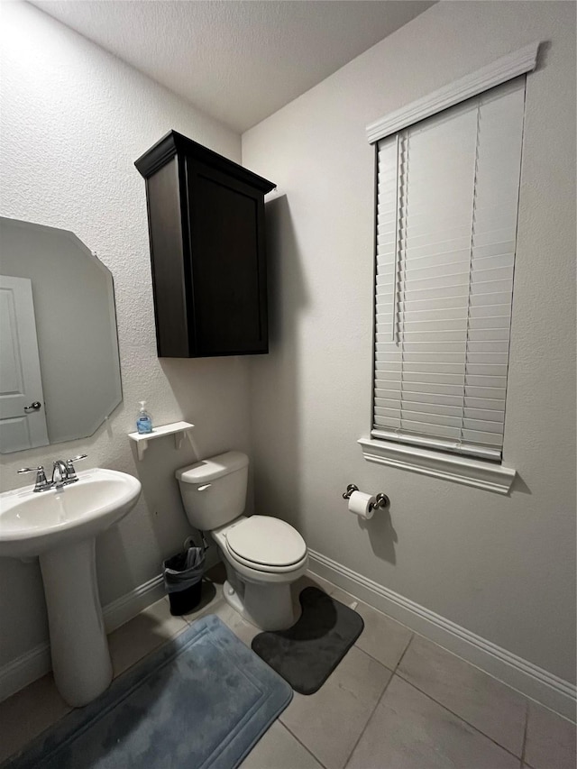 bathroom featuring tile patterned floors, sink, a textured ceiling, and toilet