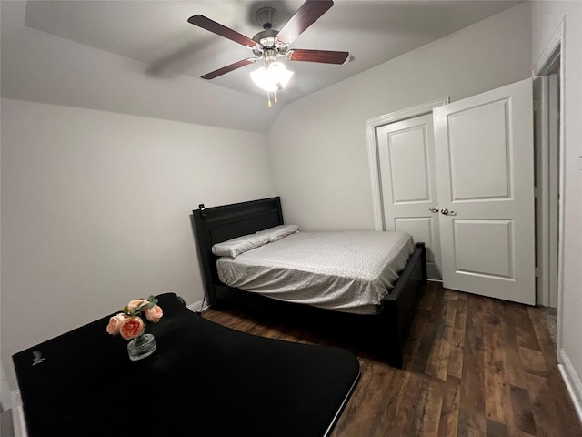 bedroom featuring ceiling fan, a closet, dark hardwood / wood-style flooring, and vaulted ceiling