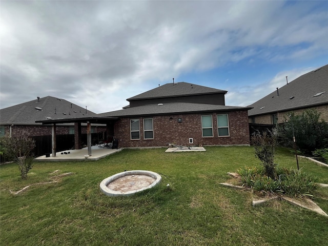 back of property featuring a fire pit, a patio area, and a lawn