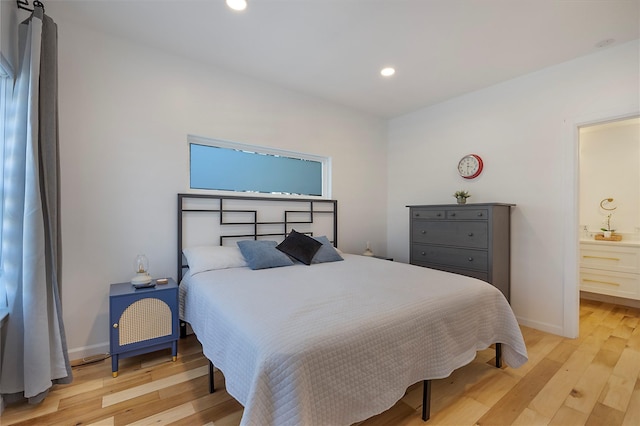 bedroom featuring light wood-type flooring and ensuite bathroom