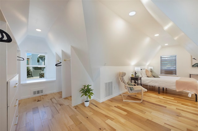 unfurnished bedroom with light wood-type flooring and vaulted ceiling