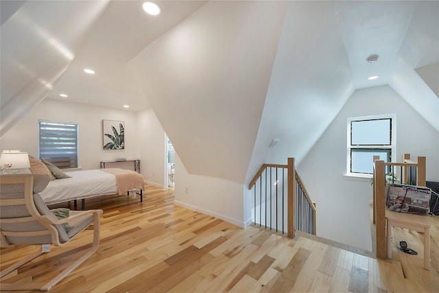 bedroom featuring vaulted ceiling, multiple windows, and light hardwood / wood-style flooring