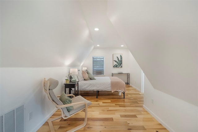 bedroom featuring light hardwood / wood-style flooring and lofted ceiling