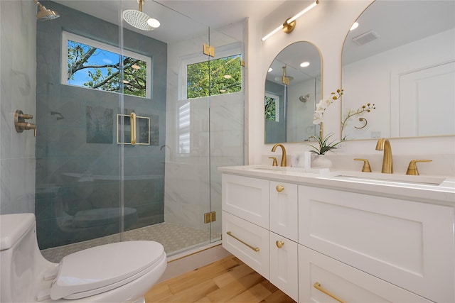 bathroom with hardwood / wood-style floors, vanity, toilet, and an enclosed shower