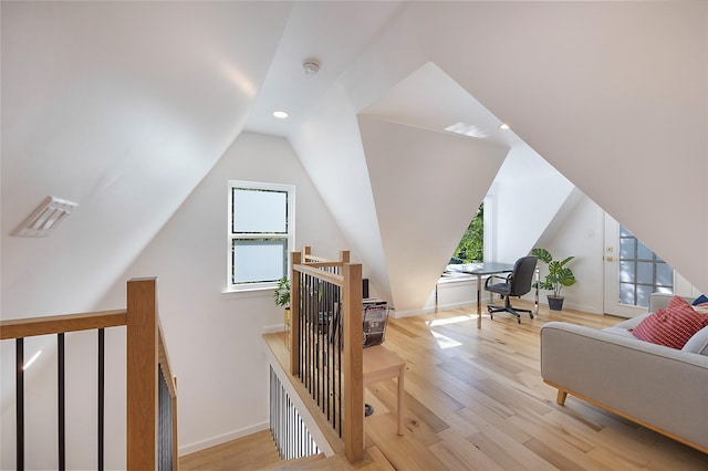 additional living space featuring lofted ceiling and light wood-type flooring