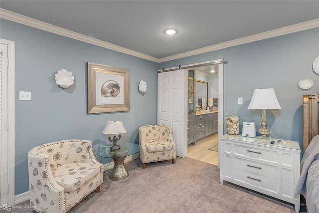 sitting room with a barn door, crown molding, and light colored carpet