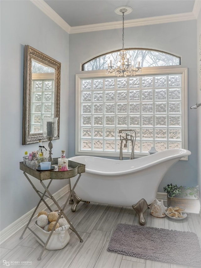 bathroom with a bathtub, ornamental molding, and an inviting chandelier