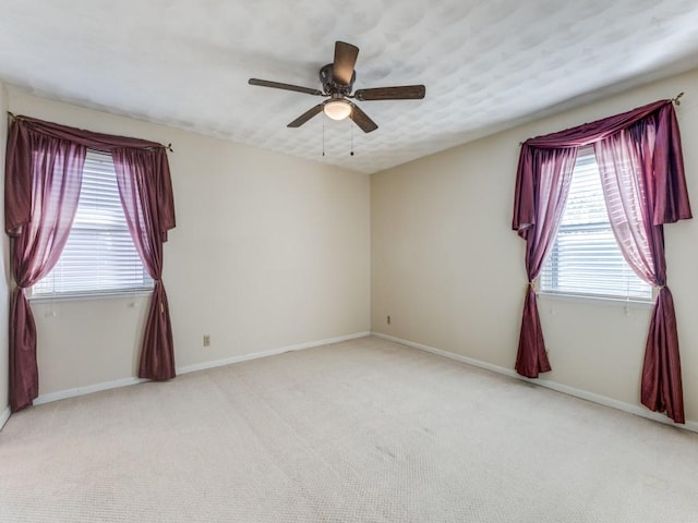 carpeted spare room with ceiling fan