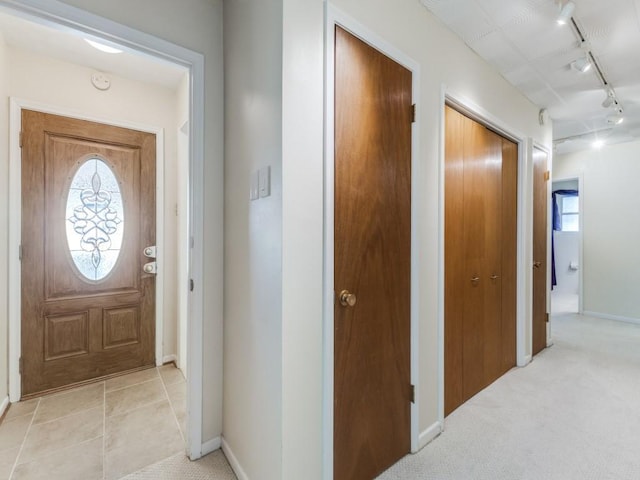 carpeted entryway with rail lighting