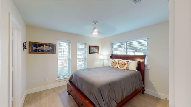 bedroom with ceiling fan, light wood-type flooring, and multiple windows