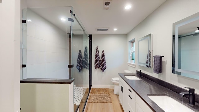 bathroom featuring a shower, wood-type flooring, vanity, and toilet