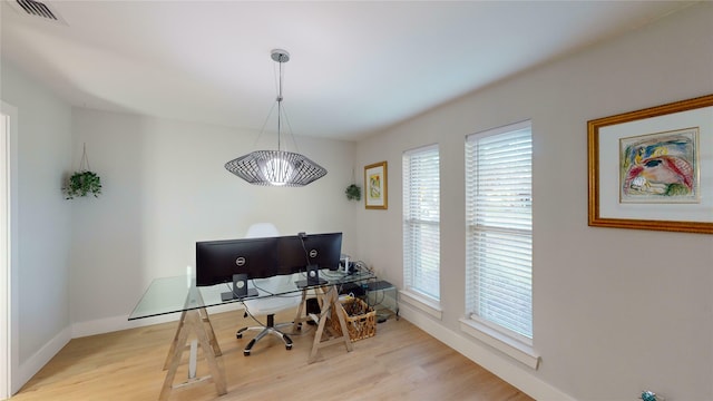 home office with light hardwood / wood-style flooring