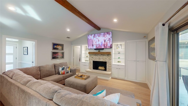 living room featuring vaulted ceiling with beams, a fireplace, and light wood-type flooring