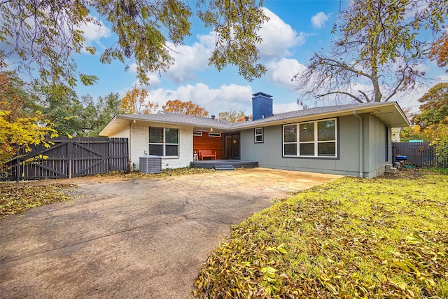 rear view of house featuring central air condition unit, a patio area, and a yard