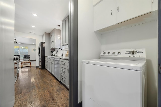 washroom with cabinets, sink, ceiling fan, dark hardwood / wood-style floors, and washer / dryer