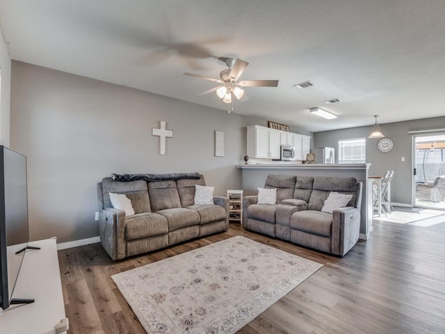 living room with hardwood / wood-style floors and ceiling fan