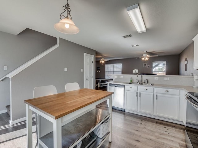 kitchen with pendant lighting, sink, white cabinets, and stainless steel appliances