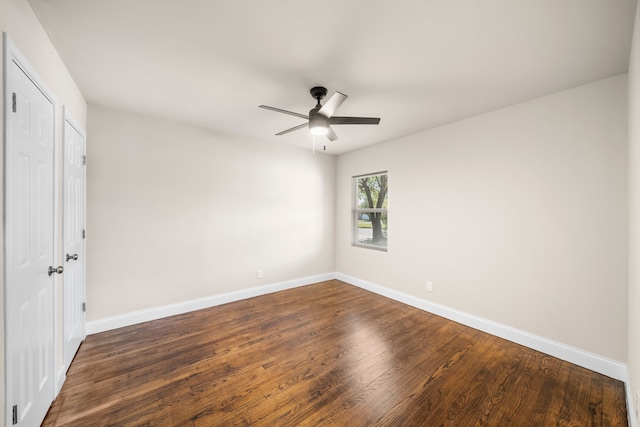 empty room with ceiling fan and dark hardwood / wood-style flooring