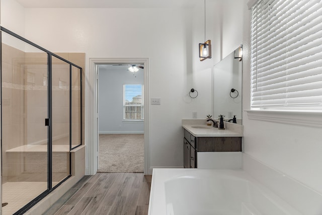 bathroom with independent shower and bath, vanity, and hardwood / wood-style floors