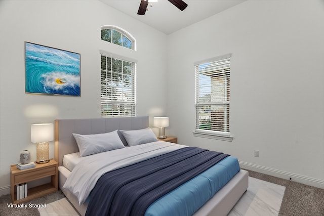 carpeted bedroom with ceiling fan and multiple windows