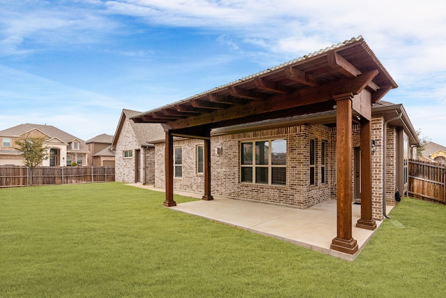 rear view of house with a lawn and a patio area