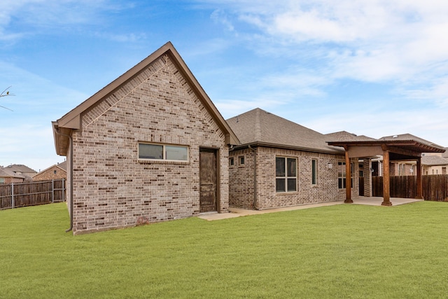 back of house featuring a lawn and a patio