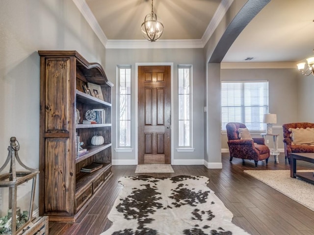 entrance foyer with crown molding, dark hardwood / wood-style floors, and an inviting chandelier