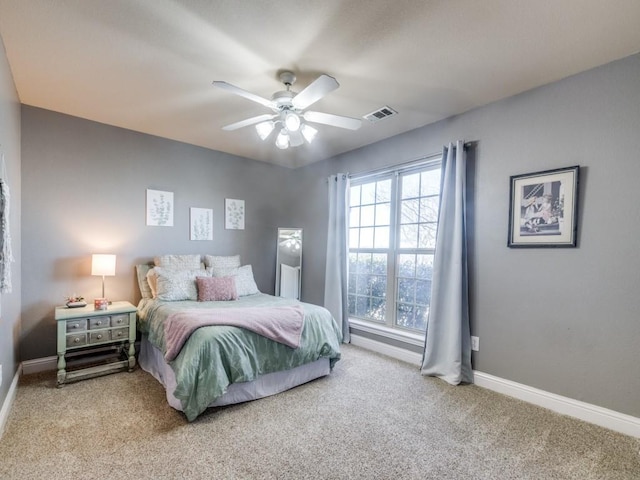 bedroom with ceiling fan, light carpet, and multiple windows