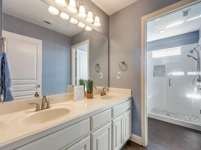 bathroom featuring hardwood / wood-style floors, vanity, and walk in shower