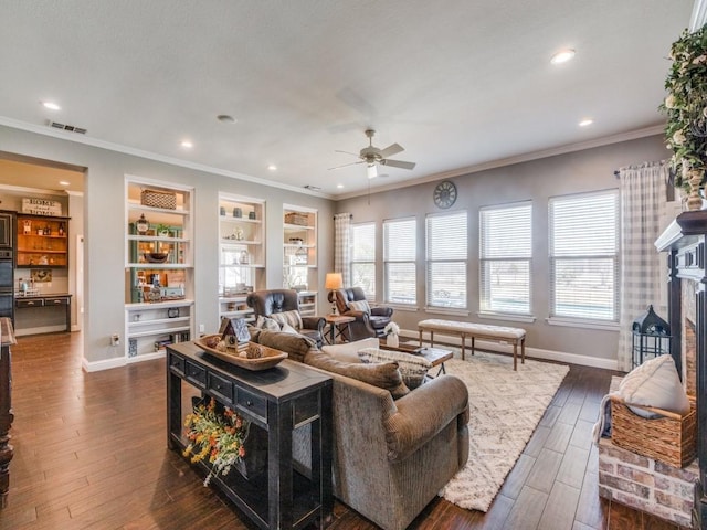 living room with a fireplace, dark hardwood / wood-style flooring, ceiling fan, and ornamental molding