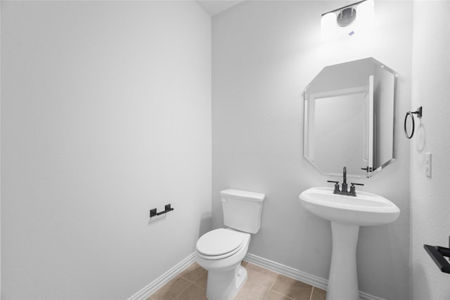 bathroom with sink, toilet, and tile patterned flooring