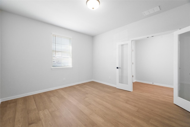 unfurnished bedroom featuring french doors and light wood-type flooring