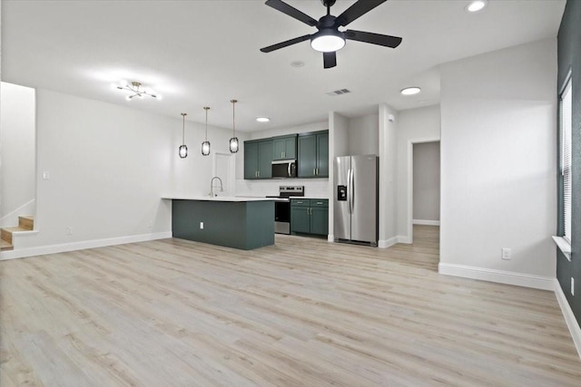 6305 Pebble Ave, Dallas, TX 75217 - kitchen featuring pendant lighting, light wood-type flooring, stainless steel appliances, and sink