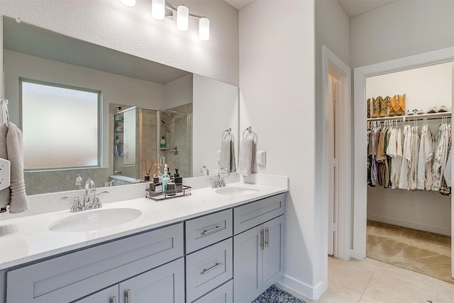 bathroom with tile patterned flooring, vanity, and walk in shower