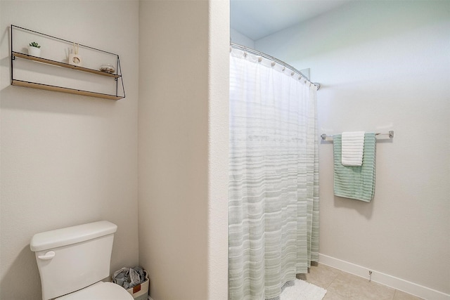 bathroom with tile patterned floors, curtained shower, and toilet