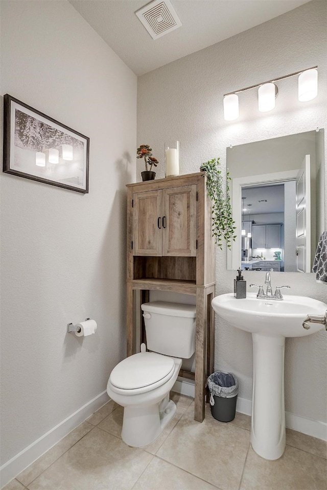 bathroom featuring tile patterned flooring, toilet, and sink