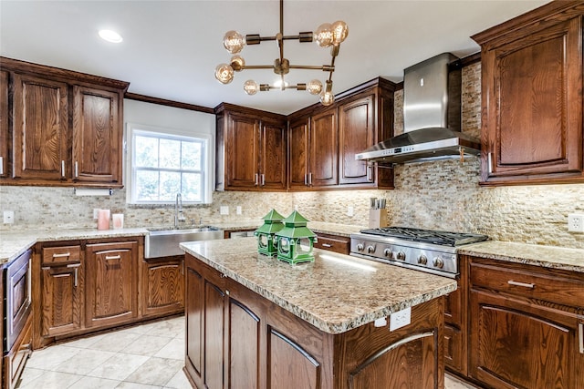 kitchen with wall chimney range hood, sink, ornamental molding, tasteful backsplash, and a kitchen island